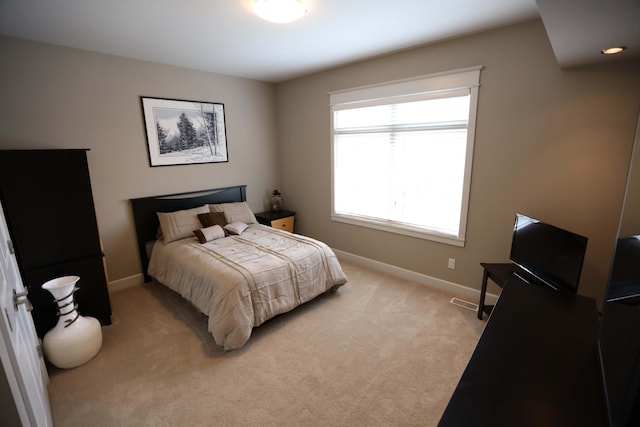 bedroom featuring baseboards and light colored carpet