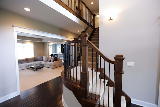 stairway with baseboards, recessed lighting, and wood-type flooring