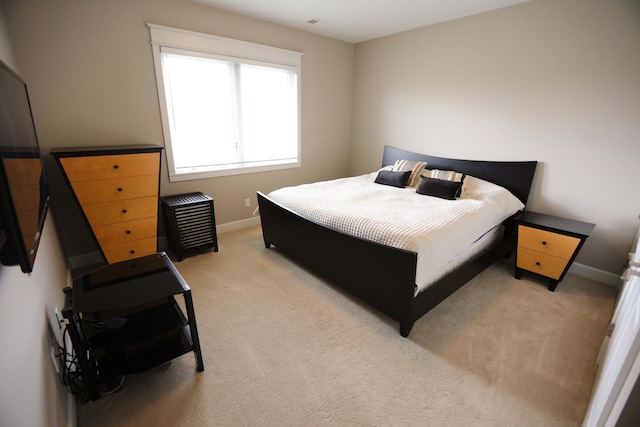 bedroom featuring baseboards and light carpet
