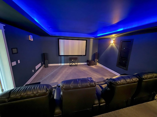 carpeted home theater featuring baseboards and a tray ceiling