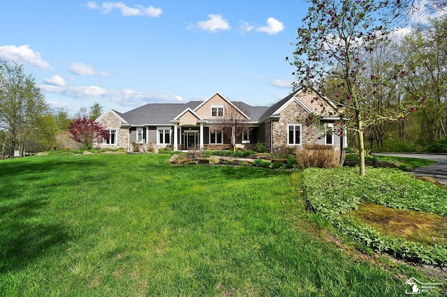craftsman inspired home with stone siding and a front lawn