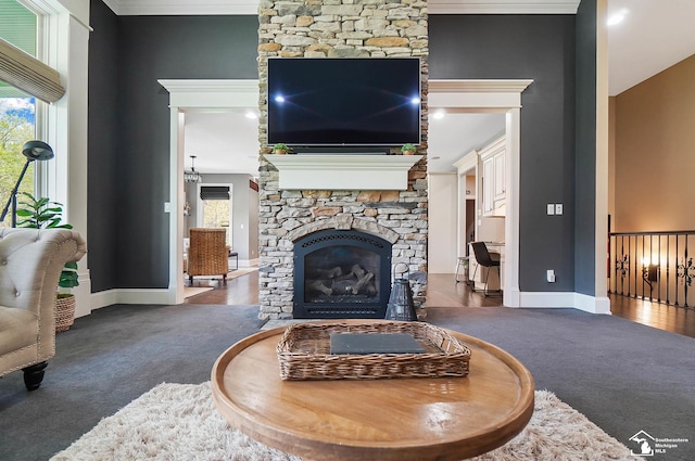 living area featuring carpet floors, baseboards, a wealth of natural light, and a fireplace
