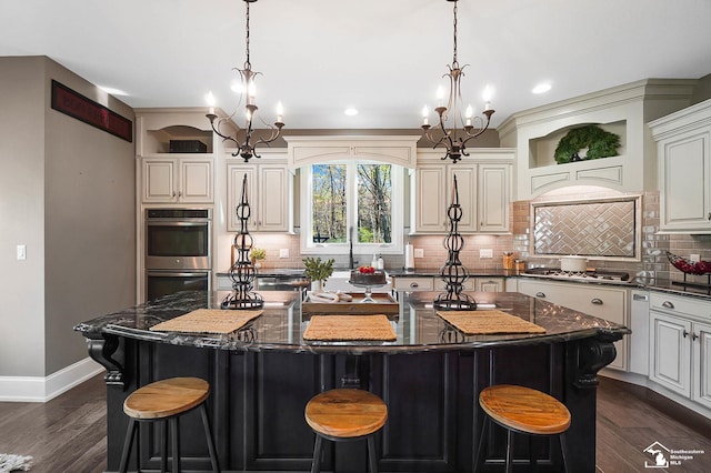 kitchen featuring a center island, open shelves, baseboards, a chandelier, and stainless steel appliances