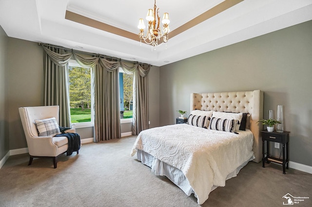 carpeted bedroom with crown molding, baseboards, a tray ceiling, and a chandelier