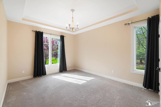 carpeted empty room featuring a raised ceiling, baseboards, a chandelier, and visible vents