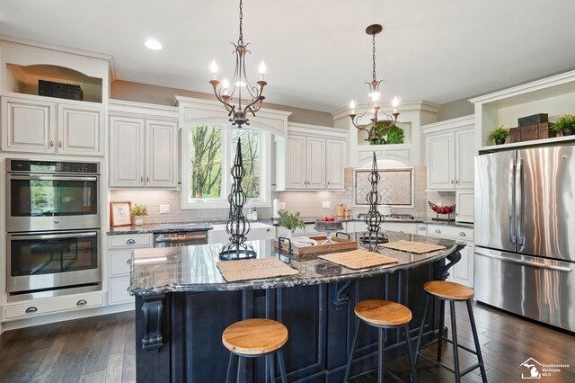 kitchen featuring open shelves, dark stone counters, a kitchen island, and stainless steel appliances