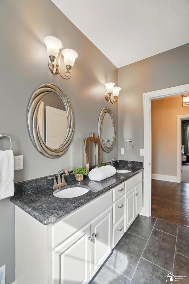 full bath featuring double vanity, a sink, and tile patterned flooring