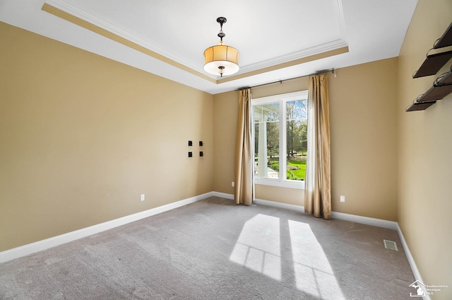 spare room featuring crown molding, carpet, baseboards, a tray ceiling, and visible vents