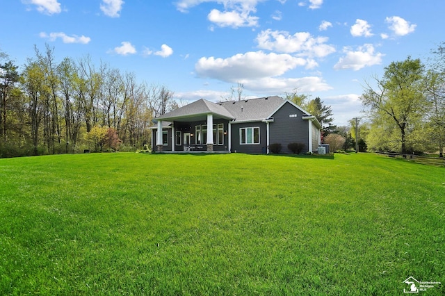 rear view of house featuring a yard