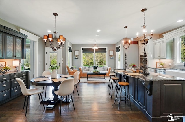 dining area featuring recessed lighting, an inviting chandelier, and dark wood-type flooring