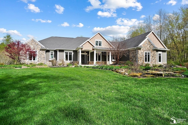 view of front of home with a front yard and stone siding