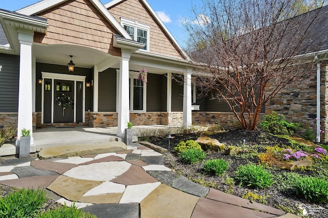 entrance to property featuring covered porch and stone siding