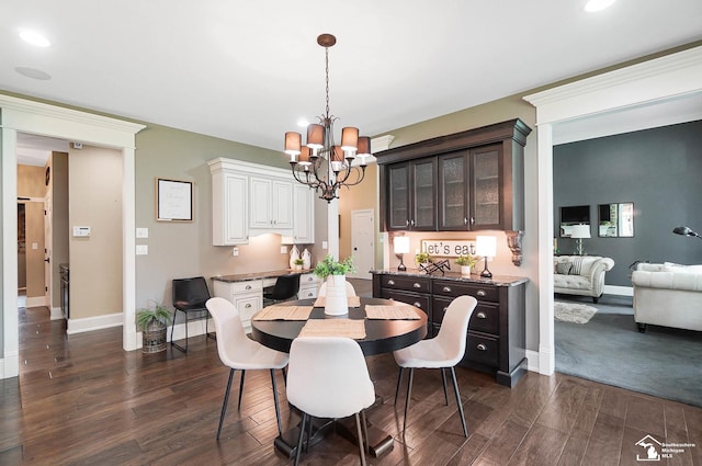 dining space with baseboards, dark wood-type flooring, recessed lighting, and a notable chandelier