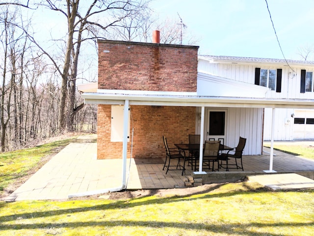 3100 Whipple Rd, Jackson, MI 49201 - rear view of property featuring board and batten siding, a patio area, and brick siding