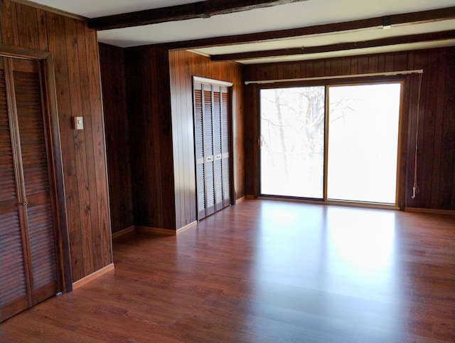 3100 Whipple Rd, Jackson, MI 49201 - unfurnished room featuring baseboards, beamed ceiling, wood walls, and wood finished floors