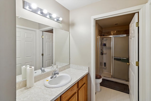 bathroom with an enclosed shower, vanity, tile patterned flooring, and toilet