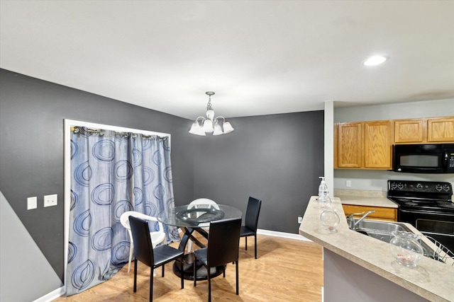 dining space featuring recessed lighting, baseboards, an inviting chandelier, and light wood-style floors