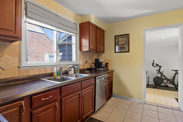 kitchen with a sink, dishwasher, dark countertops, and tasteful backsplash