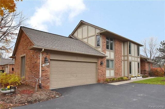view of front facade featuring a shingled roof, an attached garage, brick siding, and aphalt driveway