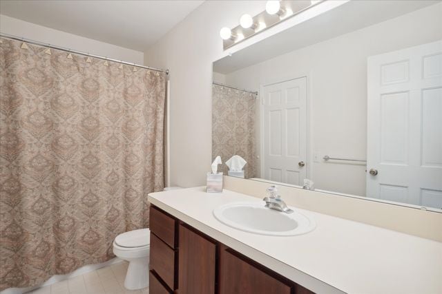 bathroom with vanity, tile patterned flooring, and toilet