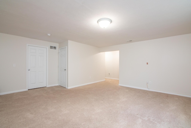 unfurnished room featuring baseboards, visible vents, and light colored carpet