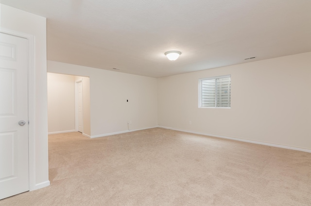 unfurnished room with baseboards, light carpet, and visible vents