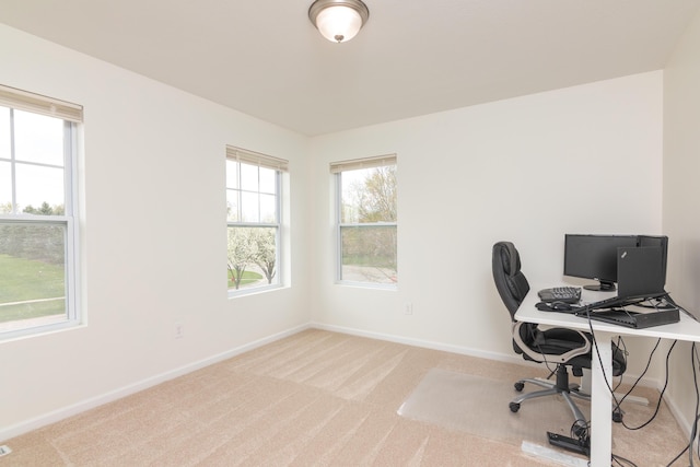 office space featuring baseboards and light colored carpet
