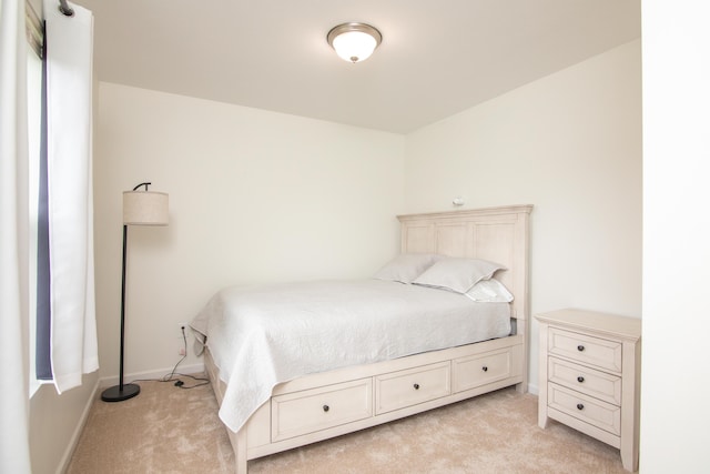 bedroom featuring baseboards and light colored carpet