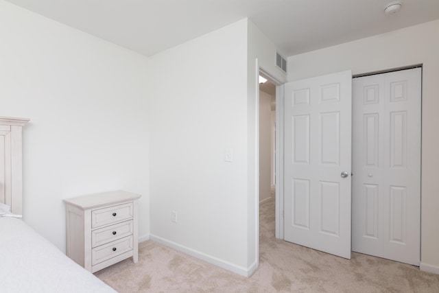 unfurnished bedroom featuring carpet floors, baseboards, visible vents, and a closet