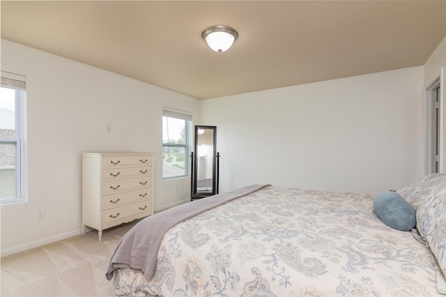 bedroom featuring light colored carpet and baseboards