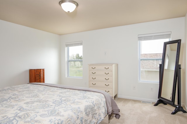 bedroom with light colored carpet, baseboards, and visible vents