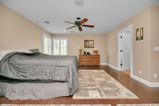 bedroom featuring ceiling fan, visible vents, wood finished floors, baseboards, and recessed lighting