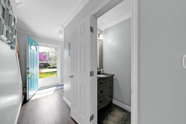 interior space featuring crown molding, baseboards, and wood finished floors