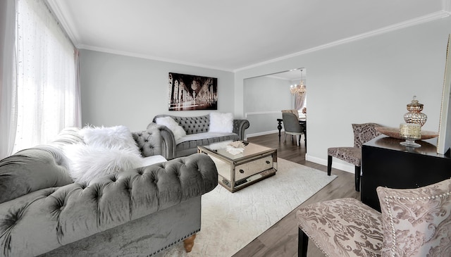 living area featuring crown molding, baseboards, an inviting chandelier, and wood finished floors