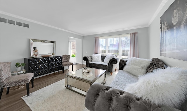 living area with ornamental molding, wood finished floors, and visible vents