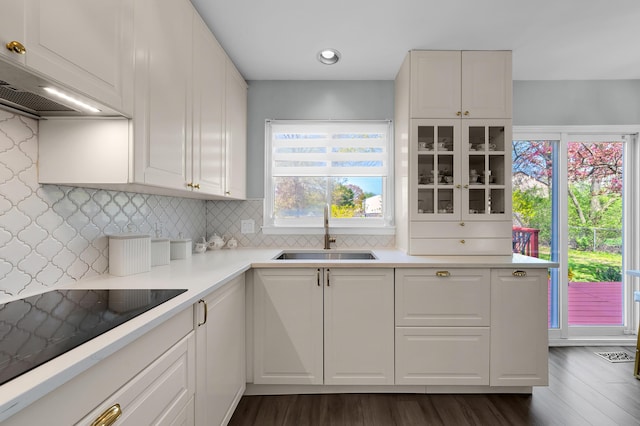 kitchen with white cabinets, backsplash, a sink, and light countertops