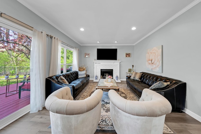living room with ornamental molding, a brick fireplace, baseboards, light wood-style floors, and recessed lighting