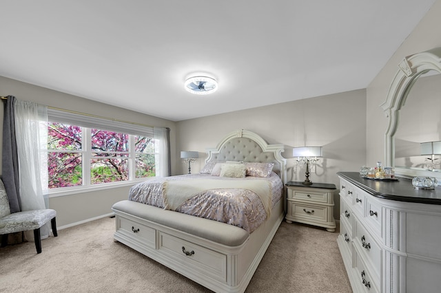 bedroom with baseboards and light carpet