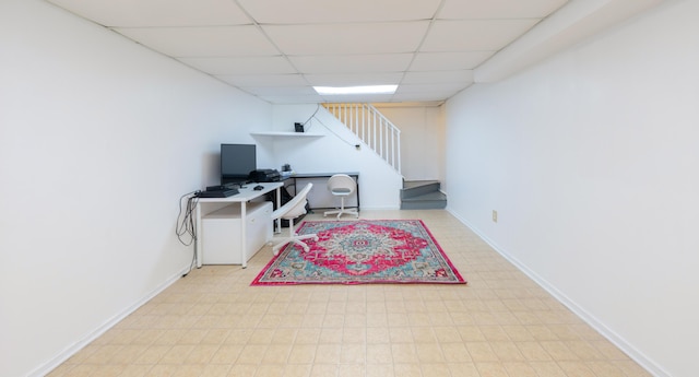 office space featuring baseboards and a drop ceiling