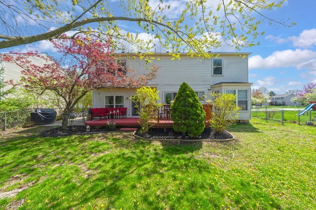 rear view of property featuring a fenced backyard, a yard, and a deck