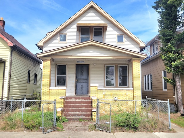 view of front of home with brick siding, a gate, and a fenced front yard