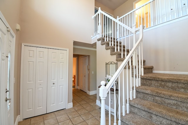 51466 Promenade Ln, New Baltimore, MI 48047 - stairway with a towering ceiling, baseboards, and tile patterned floors