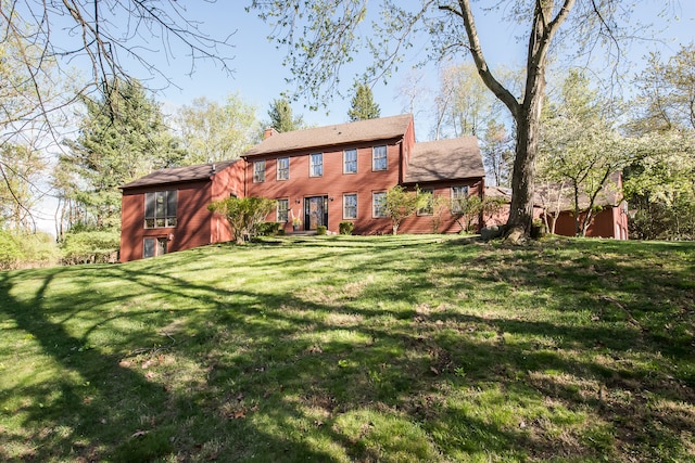 back of property featuring a lawn and a chimney