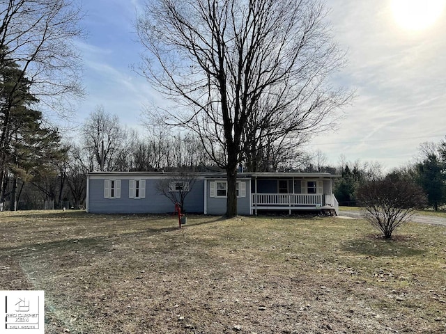manufactured / mobile home with covered porch and a front yard