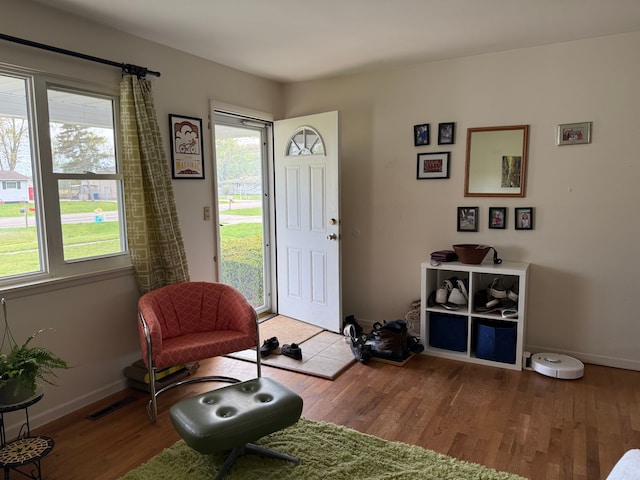 sitting room with visible vents, baseboards, and wood finished floors