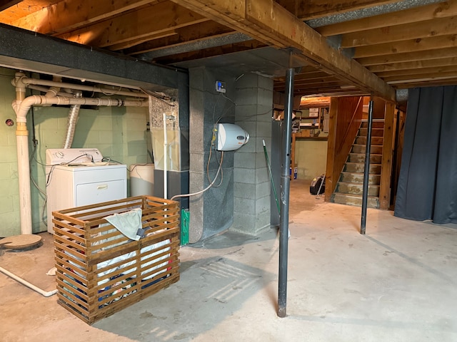 unfinished below grade area featuring stairs and washer / dryer