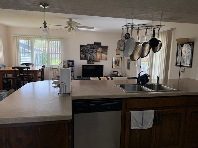 kitchen with ceiling fan, dishwasher, a sink, light countertops, and open floor plan