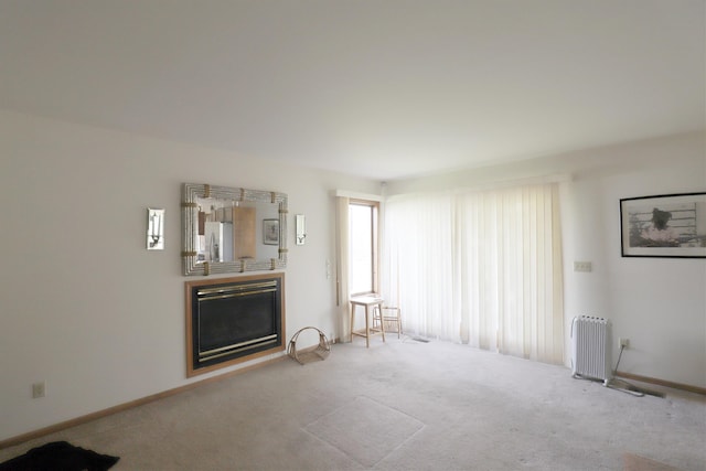 unfurnished living room with baseboards, carpet, and a fireplace