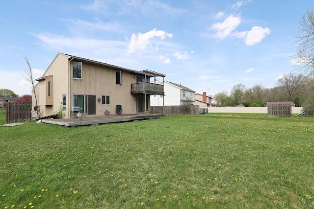 back of house featuring a lawn, fence, and a deck