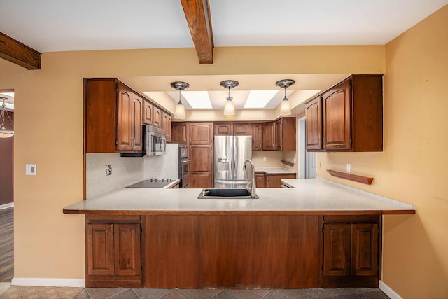 kitchen with appliances with stainless steel finishes, a sink, light countertops, a peninsula, and baseboards